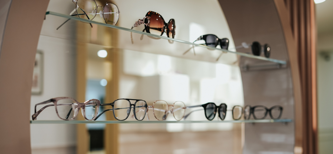 Two rows of glasses, displayed on glass shelves inside Edwards & Walker Opticians Doncaster.