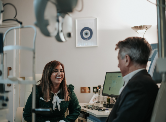 Dr Pretty Basra laughing with male patient during eye test at Edwards & Walker Opticians Doncaster.